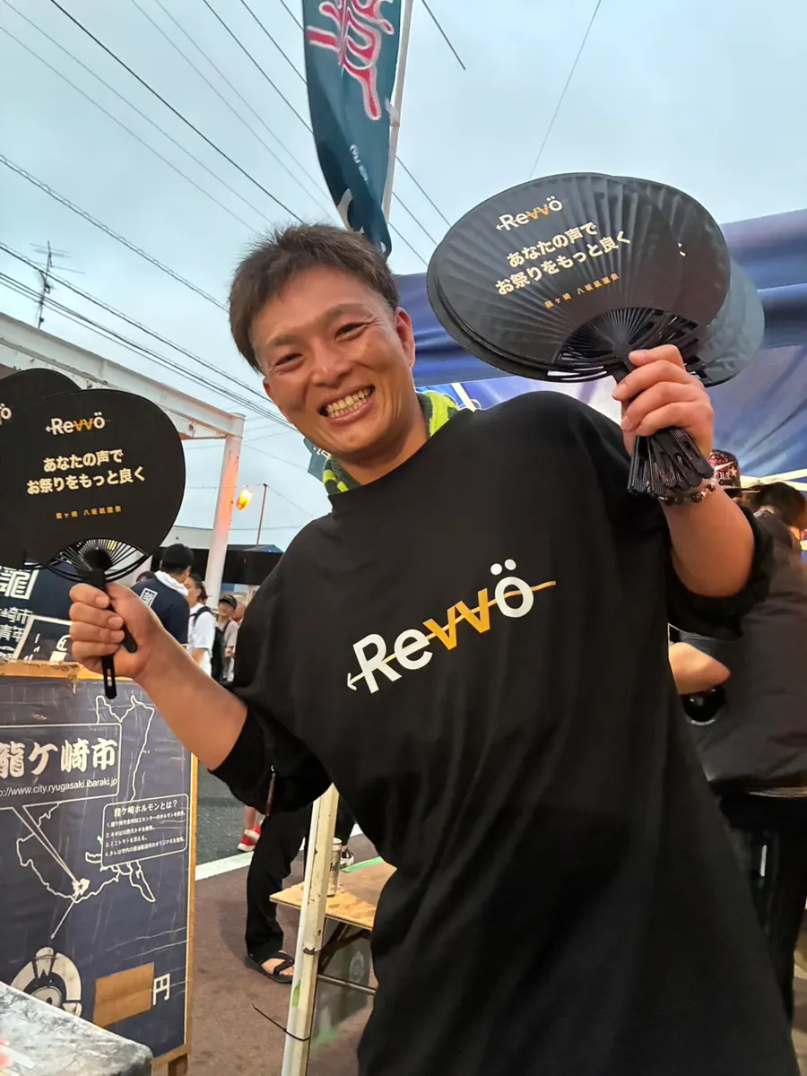 会場で配ったRevvöのうちわを持つスタッフ